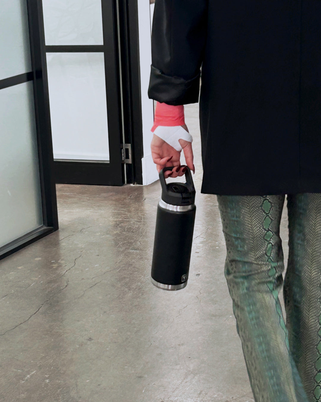 Hotstuff Hydroheat Wrist Relief patch worn while holding a water bottle, showing everyday wrist pain relief support.